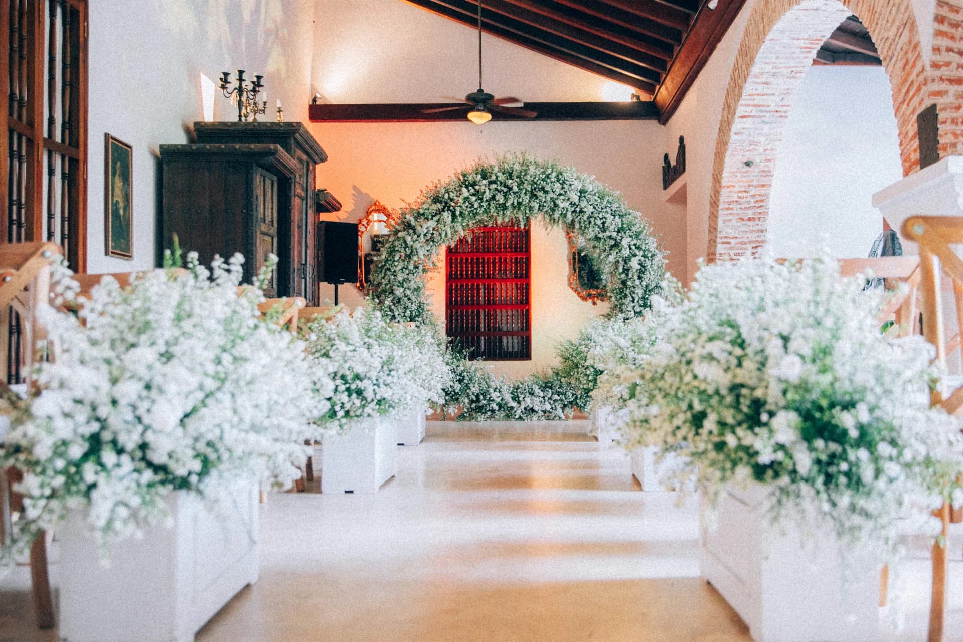 Floral arch and a flower-lined aisle set for a wedding ceremony in a colonial house in Cartagena
